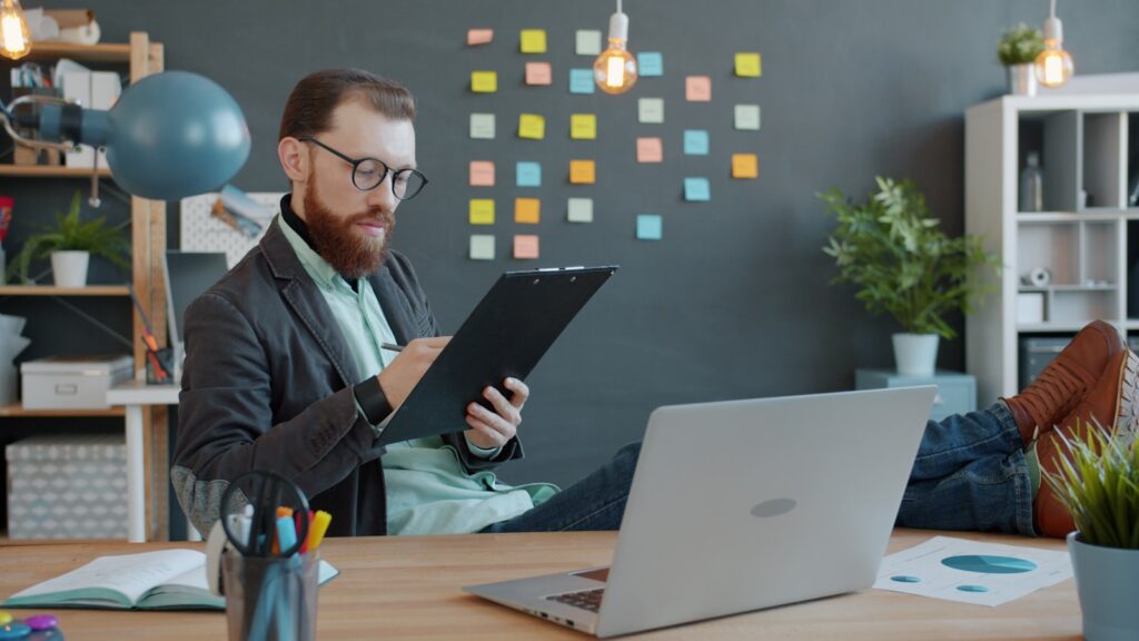 Person at a desk with a laptop and printed documents nearby